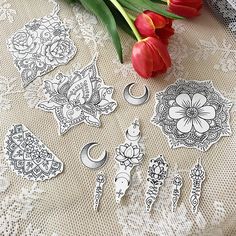 some flowers are sitting on a table next to doily and paper cutouts