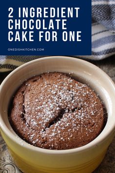 two ingredient chocolate cake for one in a yellow bowl with powdered sugar on top