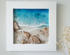 an aerial view of the beach and ocean from above, framed in a white frame