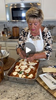 a woman in an apron preparing food on top of a counter