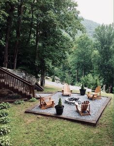 an outdoor fire pit surrounded by lawn chairs and trees in the background with steps leading up to it