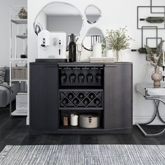 a black cabinet with wine glasses on it in front of a mirror and other items