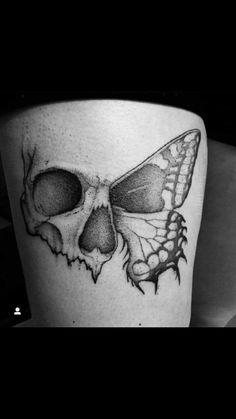 a black and white photo of a skull with a butterfly on it's side