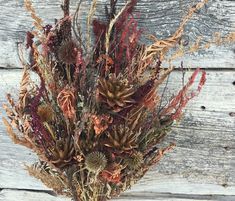 an arrangement of dried flowers on a wooden surface