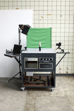 a laptop computer sitting on top of a table next to a camera and tripod