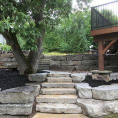 stone steps lead up to a deck and tree