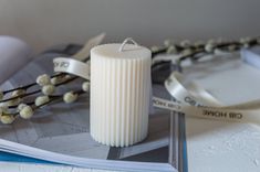 a white candle sitting on top of a book