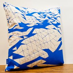 a blue and white pillow sitting on top of a wooden table