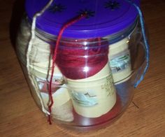 a jar filled with yarn sitting on top of a wooden table