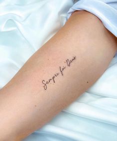 a person with a tattoo on their arm that says, surprise for pleasure in cursive writing