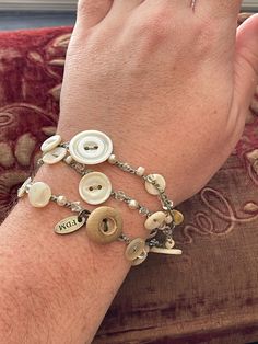 a person wearing a bracelet with buttons on it