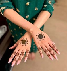 two hands with henna designs on them and one hand holding a coin in the other