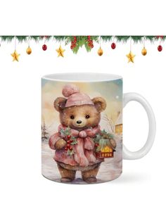 a coffee mug with a teddy bear wearing a pink hat and scarf holding a christmas ornament