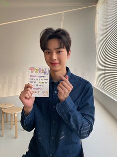 a young man holding up a piece of paper