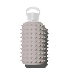 a white ceramic bottle with spikes on the top and bottom, in front of a white background