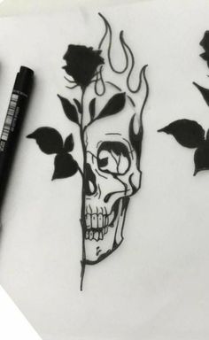 a drawing of a skull with roses on it and a black marker next to it