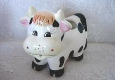 a ceramic cow figurine sitting on top of a table