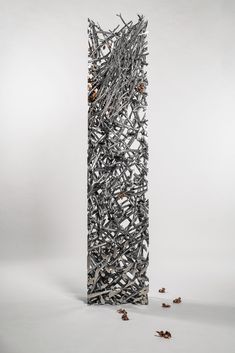 a tall metal structure with lots of small objects on it's sides and the bottom half