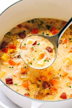 a ladle full of soup with potatoes and ham