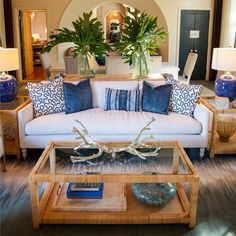 a living room filled with lots of furniture and plants on top of it's tables