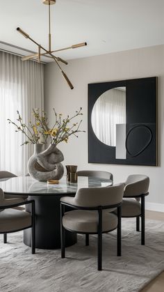 a dining room table with chairs and a vase filled with flowers on top of it