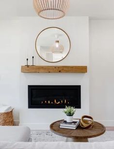 a living room with white furniture and a fire place in the fireplace mantels