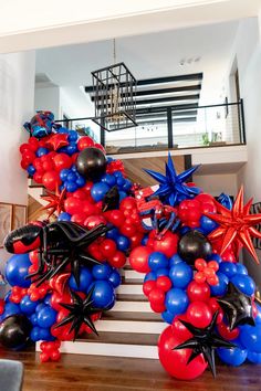 red, white and blue balloons in the shape of spider - man are on display