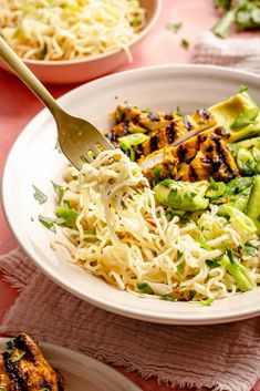 a white bowl filled with noodles and broccoli on top of a pink table