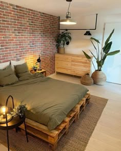 a bed made out of wooden pallets in a room with brick walls and flooring