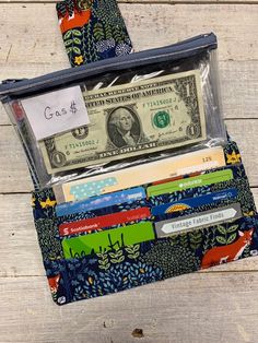 an open wallet with money in it sitting on top of a wooden table