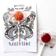 a candy lollipop is sitting on top of a valentine's card