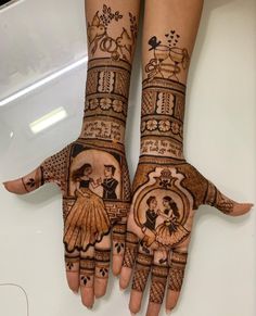 two hands that are decorated with henna and tattoos on them, one is holding the other