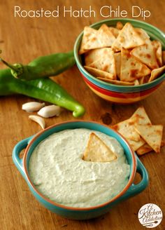 a bowl filled with dip next to some crackers and green peppers on the side