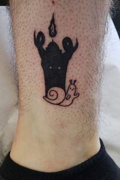 a small tattoo on the ankle of a man with a cow and giraffe