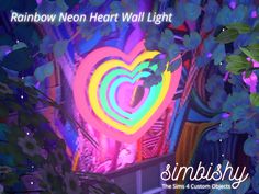 the rainbow neon heart wall light is in front of some trees and bushes with leaves