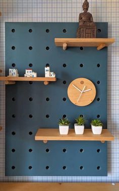 two wooden shelves with plants on them and a clock mounted to the wall behind them