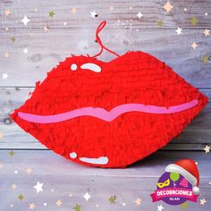 a red pillow that is shaped like a mouth with pink tongue and stars around it