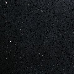 rain drops on the surface of a dark colored surface with white dots and black spots