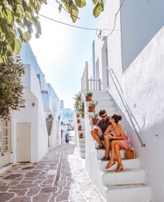 two people are sitting on the steps outside