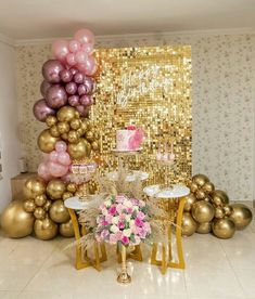 there is a table with many balloons and flowers on it in front of a gold sequin wall