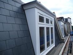 an image of a house that is being built on the side of a building with windows