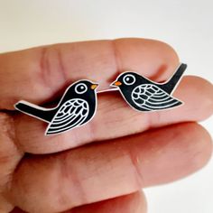 two black birds are sitting on top of each other's lapel pinback