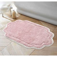 a bath mat on the floor next to a white tub and toilet in a bathroom