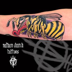 a yellow and black striped bee tattoo on the left arm with words written below it