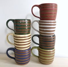 four coffee mugs stacked on top of each other