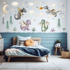 a child's bedroom decorated in blue and white with dragon decals on the wall