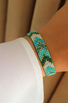 a woman's arm with a bracelet made out of beads and green glass beads