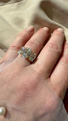 a woman's hand with a diamond ring on top of her finger and veil