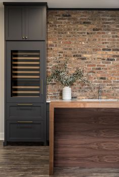 an image of a kitchen with brick wall and wooden counter top, as well as a wine rack