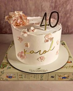 a white cake with flowers on top and the number forty - four written in gold